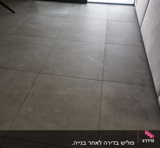 רצפה נקייה עם אריחים גדולים ליד חלון זכוכית